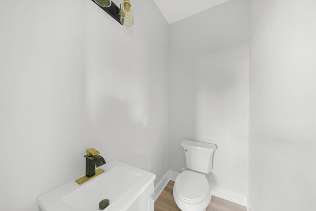 bathroom featuring vaulted ceiling, hardwood / wood-style floors, and toilet