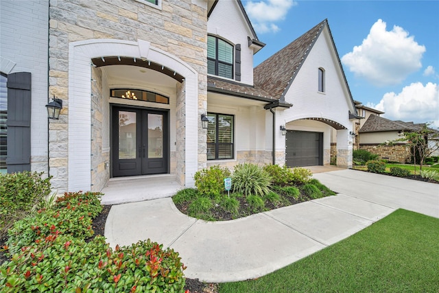 property entrance featuring a garage and french doors