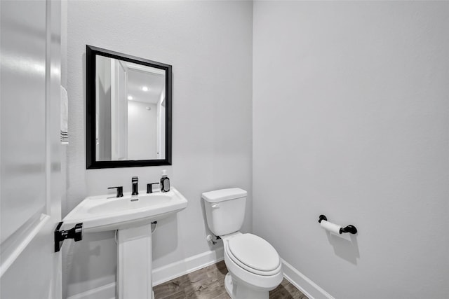 bathroom featuring hardwood / wood-style flooring and toilet