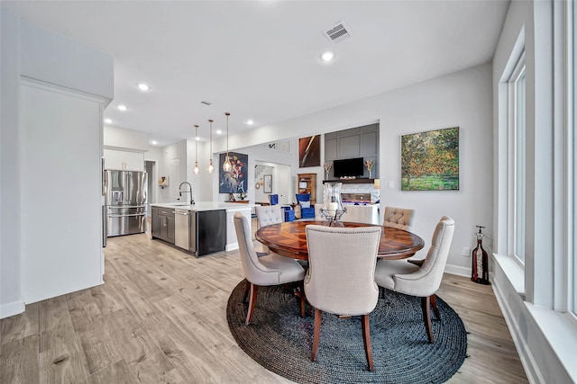 dining space featuring sink and light hardwood / wood-style floors