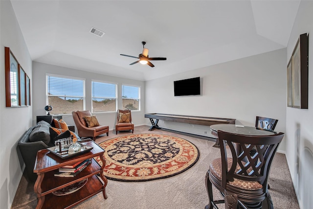 living room featuring carpet floors, ceiling fan, and a tray ceiling