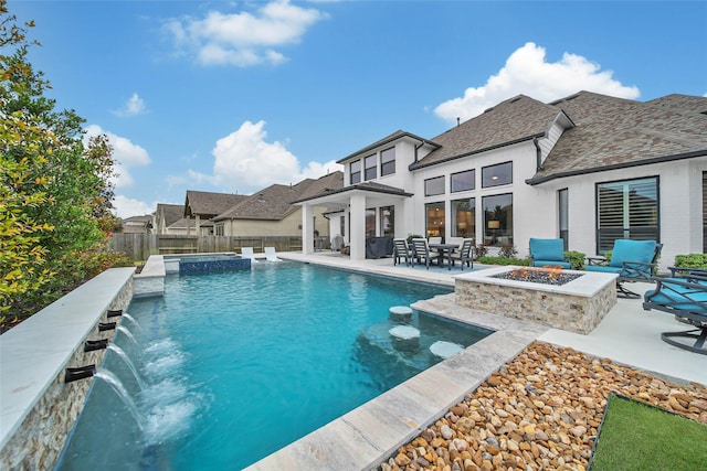 view of swimming pool with a patio, a fire pit, pool water feature, and an in ground hot tub