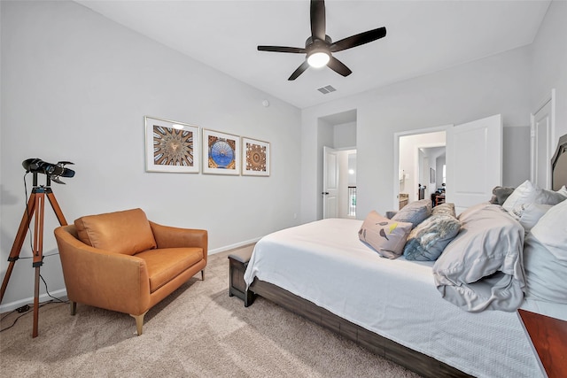 bedroom with light colored carpet, ceiling fan, and ensuite bath