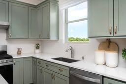 kitchen featuring appliances with stainless steel finishes, light countertops, and a sink