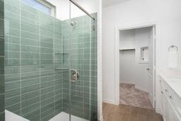 full bath with a shower stall, vanity, and wood finished floors