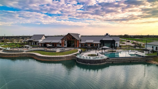 back of property with a water view and a community pool