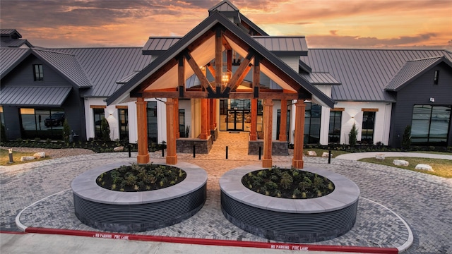 back of property at dusk with a standing seam roof and metal roof