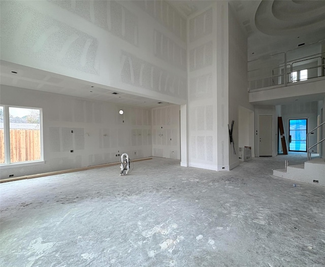 unfurnished living room with a towering ceiling