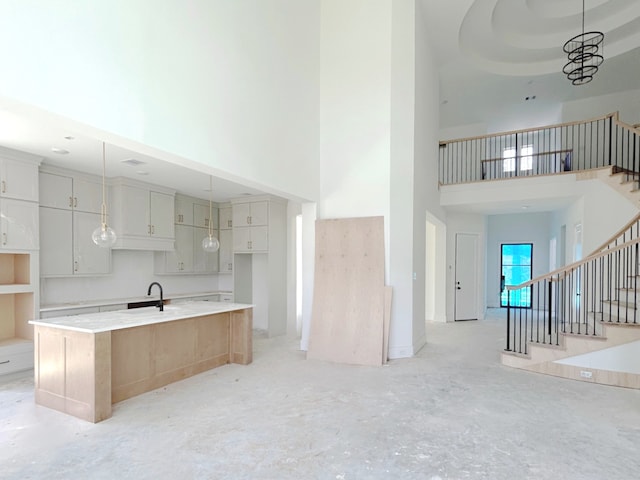 7913 Turquoise Ln, Houston, TX 77055 - kitchen featuring a high ceiling, a kitchen island with sink, hanging light fixtures, a sink, and open floor plan