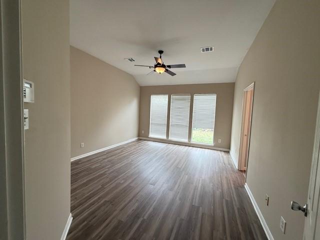 empty room featuring dark wood-type flooring, ceiling fan, and vaulted ceiling