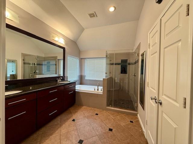 bathroom featuring vanity, tile patterned flooring, vaulted ceiling, and independent shower and bath