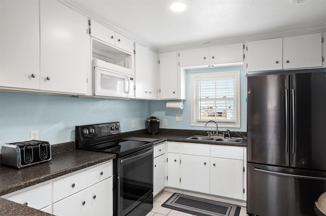 kitchen with sink, light tile patterned floors, stainless steel refrigerator, white cabinetry, and electric range