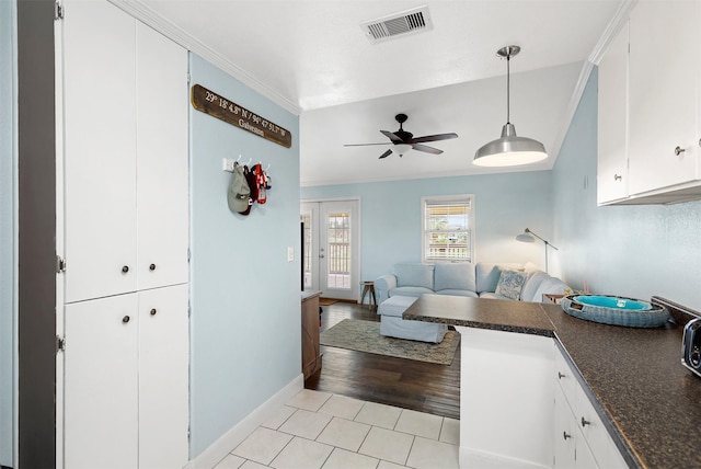 living room with crown molding, light tile patterned floors, and ceiling fan