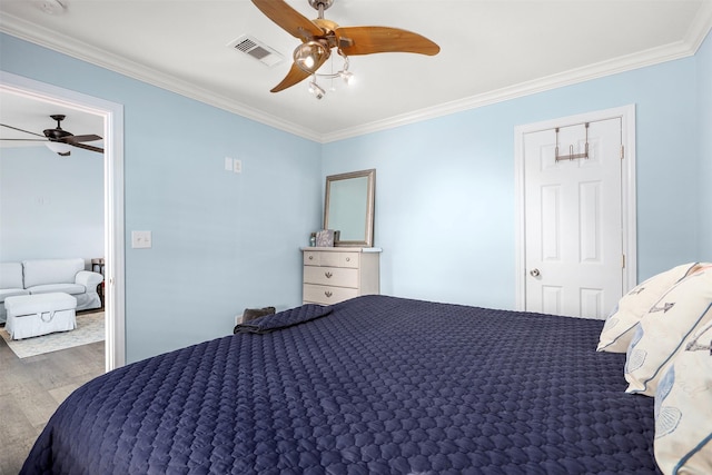 bedroom with crown molding, wood-type flooring, and ceiling fan