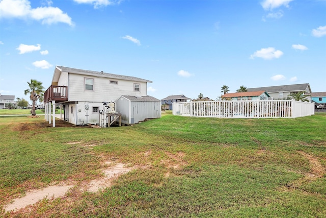 rear view of house featuring a wooden deck and a yard