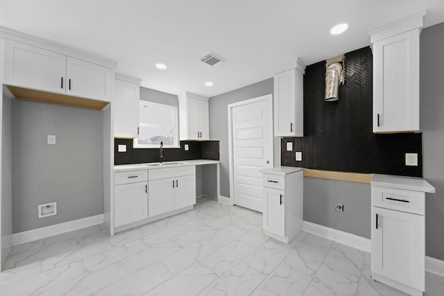 kitchen featuring white cabinetry, sink, and decorative backsplash