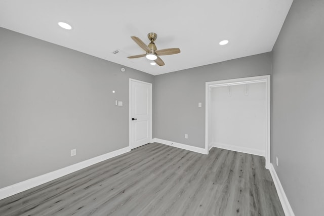 unfurnished bedroom with ceiling fan, light hardwood / wood-style floors, and a closet