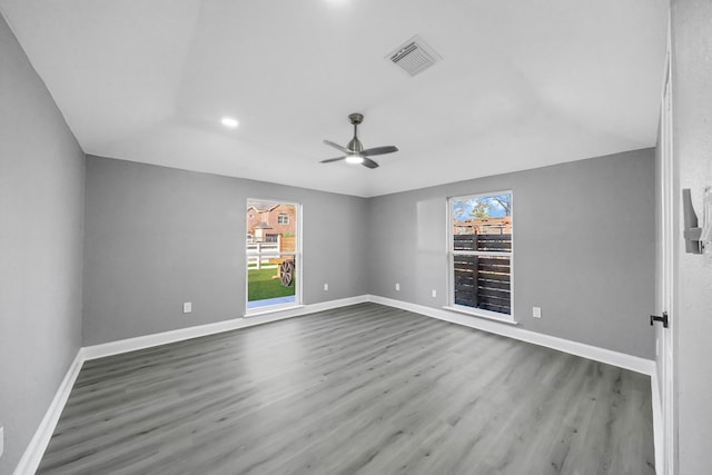 unfurnished room with dark wood-type flooring, ceiling fan, vaulted ceiling, and a wealth of natural light