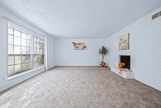 unfurnished living room with carpet flooring, a brick fireplace, and a textured ceiling