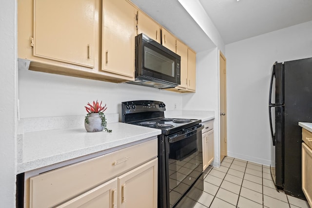 kitchen with light tile patterned floors, light brown cabinets, and black appliances