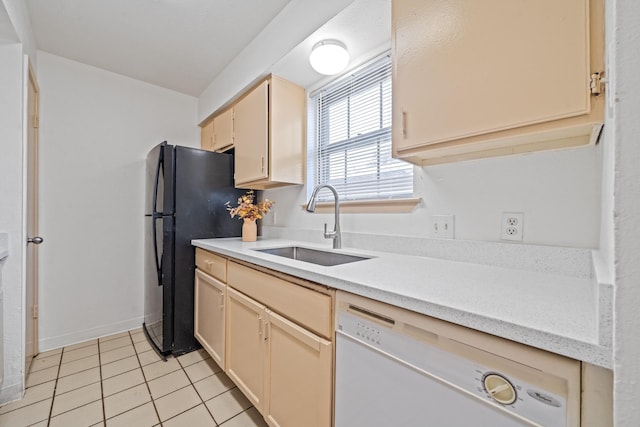 kitchen with black fridge, sink, light tile patterned floors, and white dishwasher