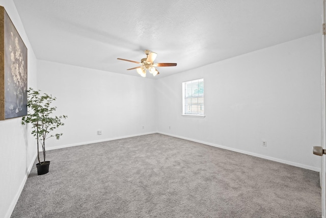 carpeted empty room with ceiling fan and a textured ceiling