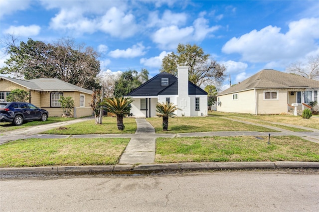 bungalow-style house featuring a front lawn