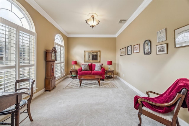 living area with crown molding and light colored carpet