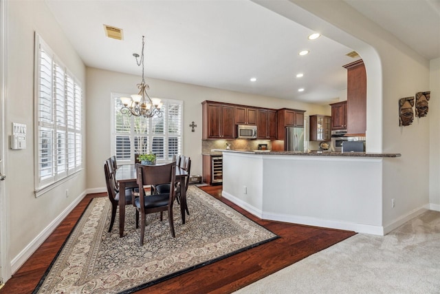 dining room with dark hardwood / wood-style floors and a chandelier