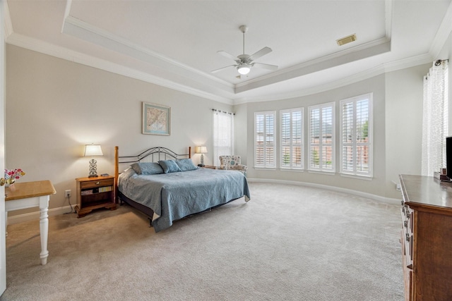 carpeted bedroom with ceiling fan, ornamental molding, and a raised ceiling