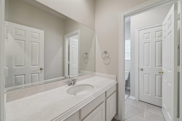 bathroom featuring vanity, tile patterned floors, and toilet