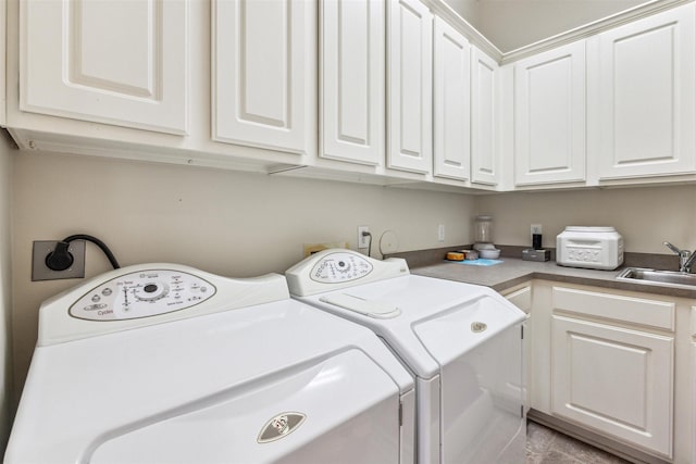 laundry room featuring cabinets, washer and dryer, and sink