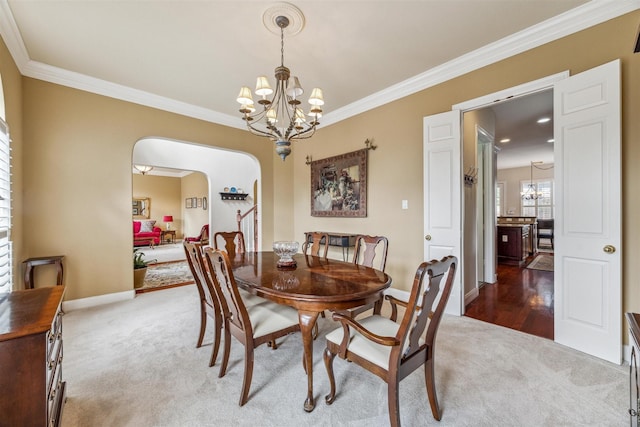 carpeted dining space featuring ornamental molding and a notable chandelier