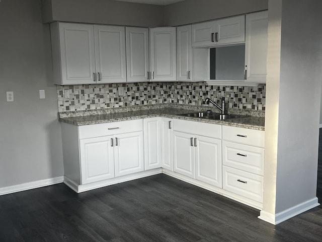 kitchen featuring tasteful backsplash, white cabinetry, sink, and dark hardwood / wood-style flooring