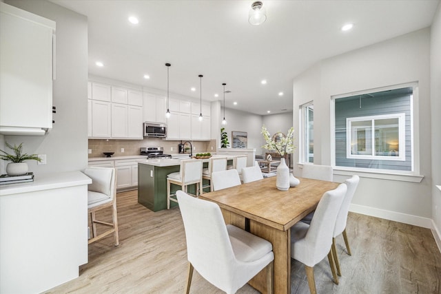 dining space with sink and light hardwood / wood-style floors