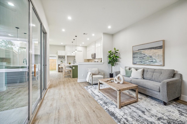 living room with sink and light hardwood / wood-style floors