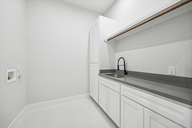 laundry area with sink, hookup for a washing machine, and cabinets