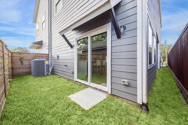 view of side of home with a lawn and central air condition unit