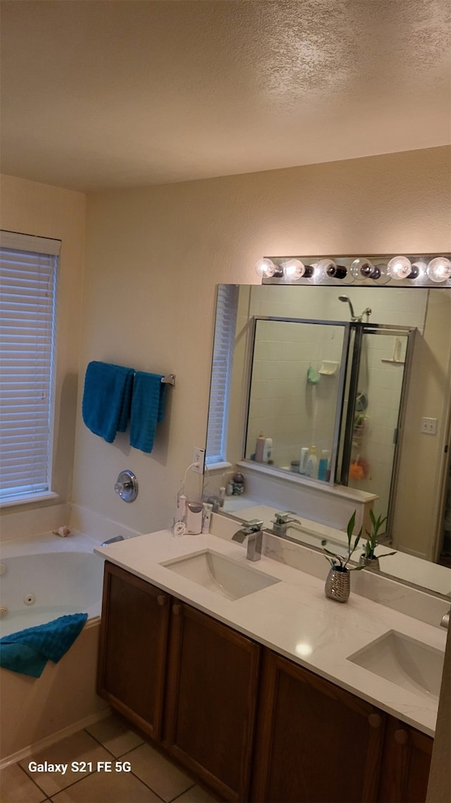 bathroom featuring vanity, tile patterned floors, plus walk in shower, and a textured ceiling