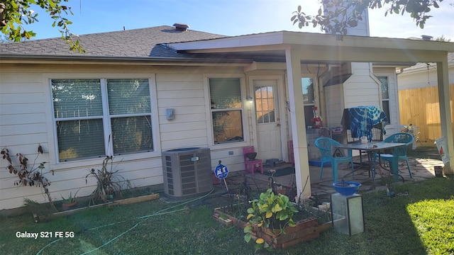 rear view of house with cooling unit, a yard, and a patio area