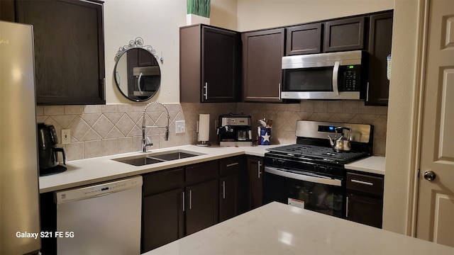 kitchen with dark brown cabinets, appliances with stainless steel finishes, sink, and decorative backsplash