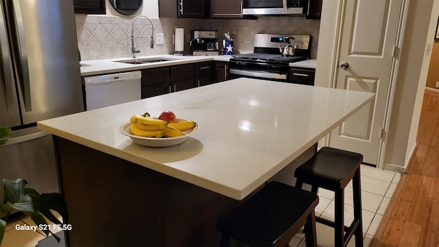 kitchen featuring tasteful backsplash, sink, a breakfast bar area, and appliances with stainless steel finishes