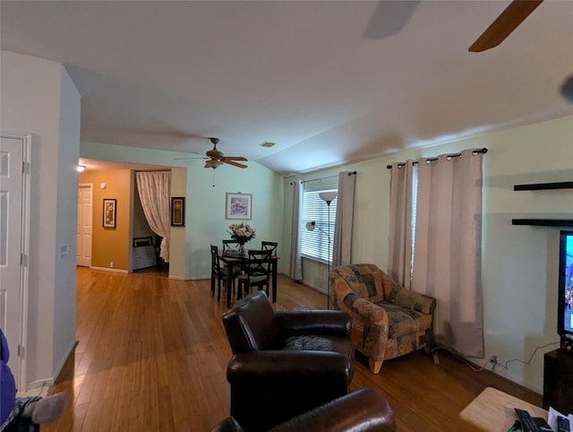 living room with ceiling fan, vaulted ceiling, and light hardwood / wood-style flooring