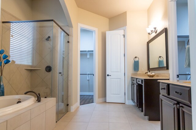 bathroom with vanity, tile patterned flooring, and plus walk in shower