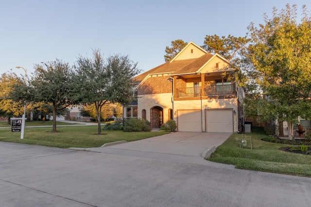 view of front facade with a balcony, a garage, central AC unit, and a front lawn