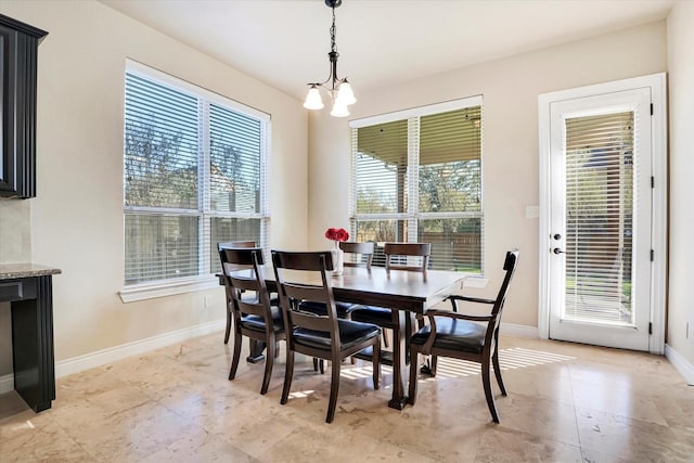 dining room featuring a healthy amount of sunlight and a chandelier