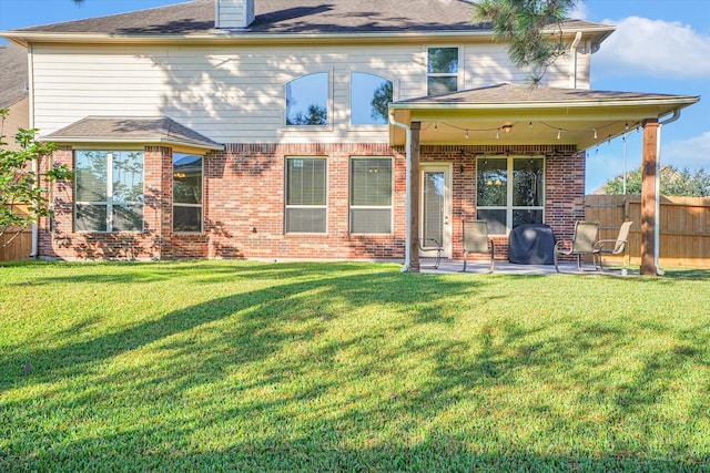 rear view of house with a yard and a patio area