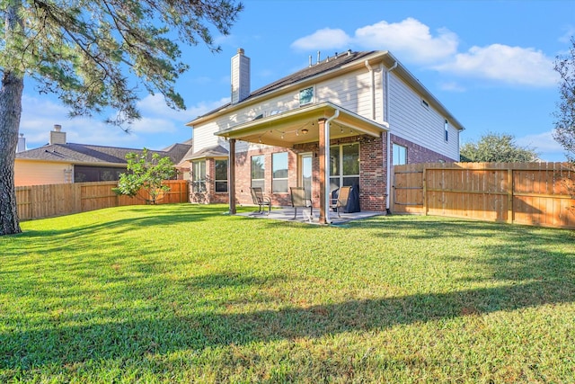 back of house with a yard and a patio area