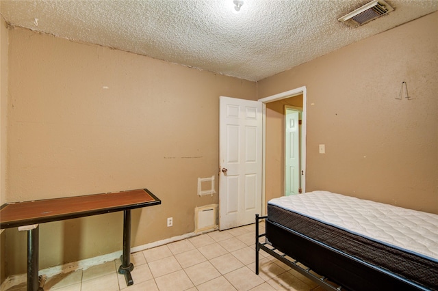 tiled bedroom featuring a textured ceiling