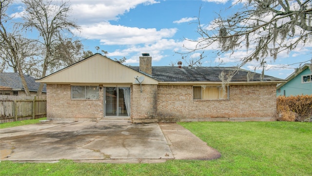 rear view of house featuring a yard and a patio